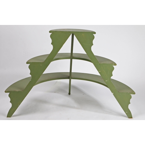 69 - A DEMI-LUNE THREE TIER PLANT STAND. with three graduated green painted shelves on silhouette support... 