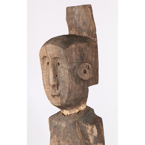 71 - A PRIMITIVE WOODEN CARVED FIGURE. Possibly Laos/ North-East Thailand, with crudely carved head and b... 