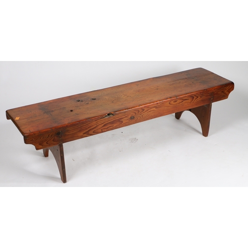 73 - A RUSTIC PINE LOW BENCH. with plank top and sides, raised on silhouette end supports, 161.5cm wide, ... 