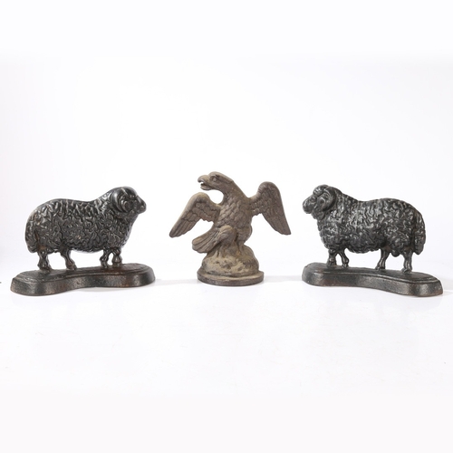 77 - THREE CAST IRON DOORSTOPS (3). consisting of a pair of rams facing left and right, 23cm wide, 16cm h... 