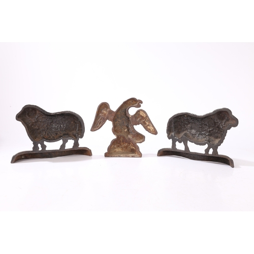 77 - THREE CAST IRON DOORSTOPS (3). consisting of a pair of rams facing left and right, 23cm wide, 16cm h... 