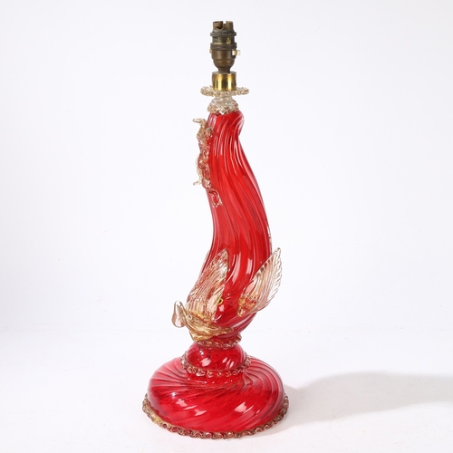 80 - A MURANO GLASS READING LAMP. modelled as a red glass dolphin with clear and gilt fins, raised on a d... 