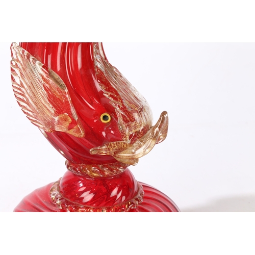 80 - A MURANO GLASS READING LAMP. modelled as a red glass dolphin with clear and gilt fins, raised on a d... 