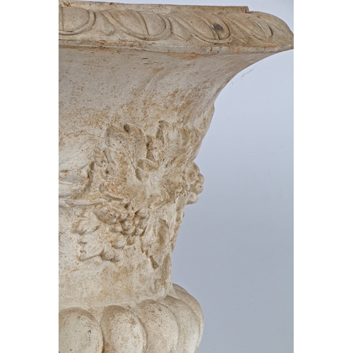 87 - A RECONSTITUTED STONE GARDEN URN. the fruiting vine decorated central band above a gadrooned lower s... 