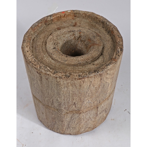 89 - A LARGE NORTH AFRICAN MORTAR. formed from a section of timber with central well and outer carved ban... 