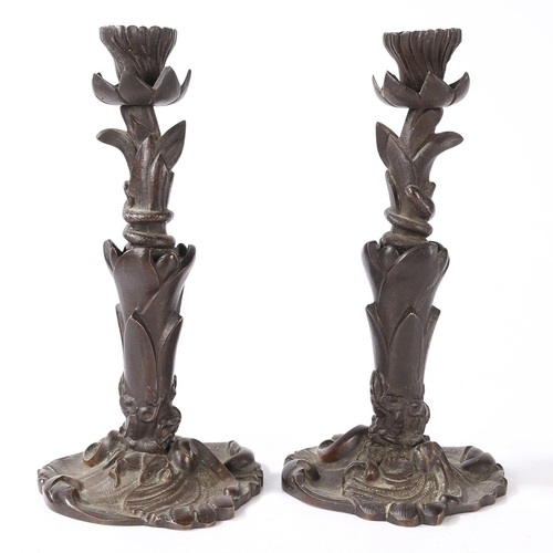 92 - A PAIR OF VICTORIAN BRONZE CANDLESTICKS. of foliate form with central entwined serpent, on a scroll ... 