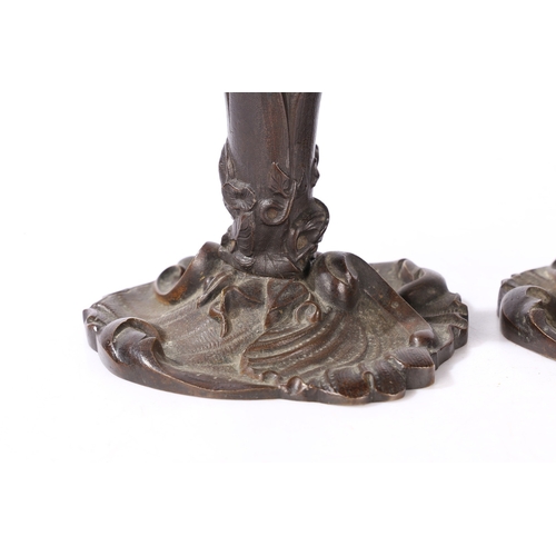 92 - A PAIR OF VICTORIAN BRONZE CANDLESTICKS. of foliate form with central entwined serpent, on a scroll ... 