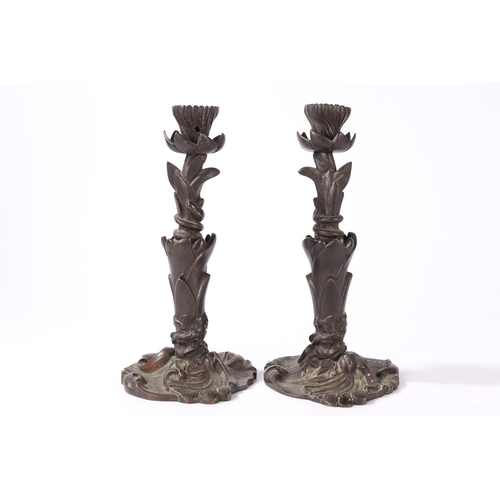 92 - A PAIR OF VICTORIAN BRONZE CANDLESTICKS. of foliate form with central entwined serpent, on a scroll ... 