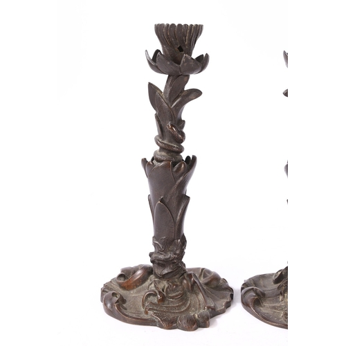 92 - A PAIR OF VICTORIAN BRONZE CANDLESTICKS. of foliate form with central entwined serpent, on a scroll ... 