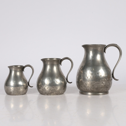 127 - A SET OF THREE GEORGE III PEWTER PRE-IMPERIAL JUGS, CIRCA 1780. Each having a pear-shaped body, with... 