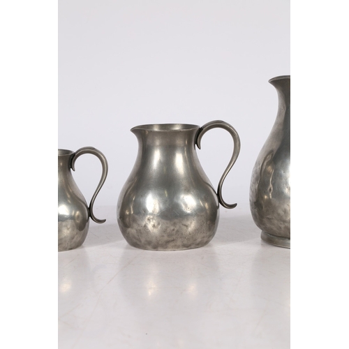 127 - A SET OF THREE GEORGE III PEWTER PRE-IMPERIAL JUGS, CIRCA 1780. Each having a pear-shaped body, with... 