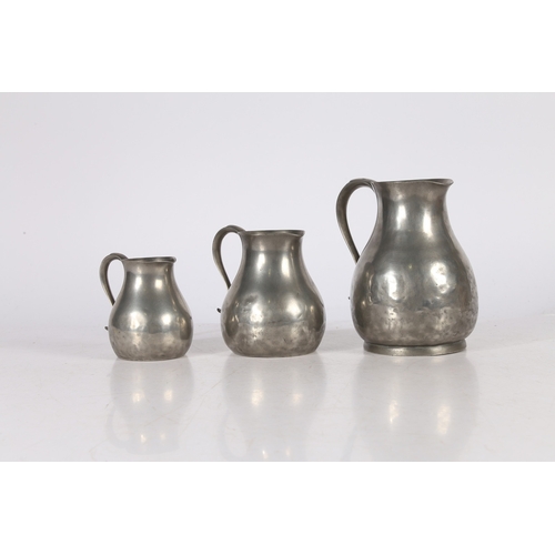 127 - A SET OF THREE GEORGE III PEWTER PRE-IMPERIAL JUGS, CIRCA 1780. Each having a pear-shaped body, with... 