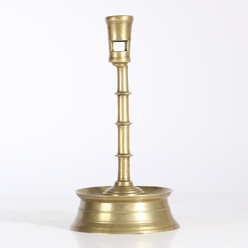 181 - A LATE 15TH CENTURY BRASS CANDLESTICK, FLEMISH, CIRCA 1450-1500. Having a tapering socket with squar... 