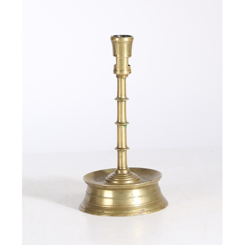 181 - A LATE 15TH CENTURY BRASS CANDLESTICK, FLEMISH, CIRCA 1450-1500. Having a tapering socket with squar... 