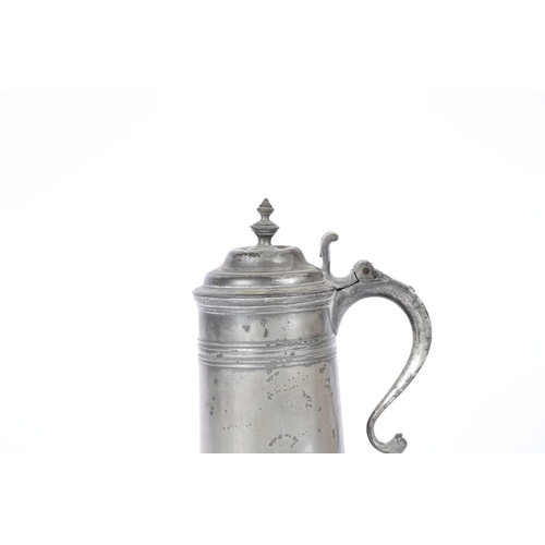 49 - A GEORGE II PEWTER SPIRE FLAGON, CIRCA 1720-50. The tapering drum with high fillet and flared skirt ... 