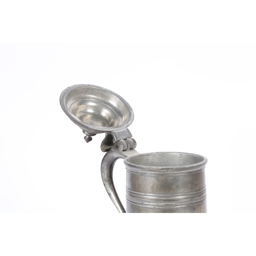 49 - A GEORGE II PEWTER SPIRE FLAGON, CIRCA 1720-50. The tapering drum with high fillet and flared skirt ... 