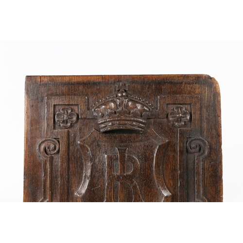 517 - AN EARLY 17TH CENTURY CARVED OAK PANEL. Centred by a large shield carved with the entwined initials ... 