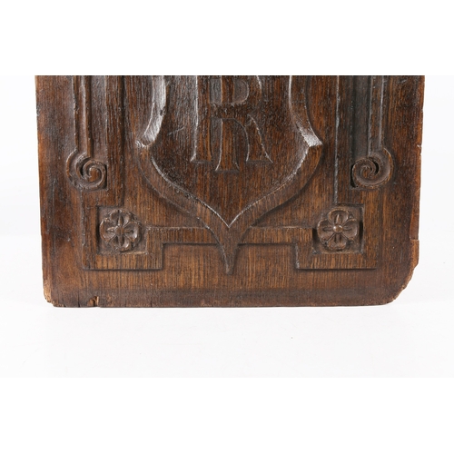 517 - AN EARLY 17TH CENTURY CARVED OAK PANEL. Centred by a large shield carved with the entwined initials ... 