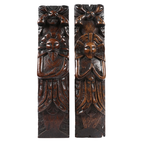 519 - A PAIR OF JAMES I CARVED OAK FIGURAL TERMS, CIRCA 1610. One male (atlantes) with folded arms, the ot... 