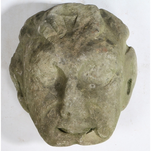 525 - AN 18TH CENTURY CARVED STONE HEAD POSSIBLY DEPICTING PAN. 29cm wide, 32cm high.