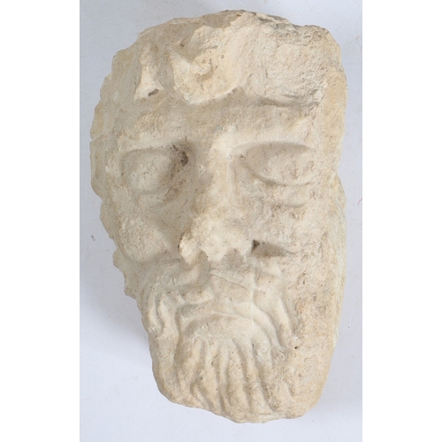 527 - AN ANTIQUE CARVED LIMESTONE HEAD, POSSIBLY JUPITER. with flowing hair and beard, 19cm wide, 28cm hig... 