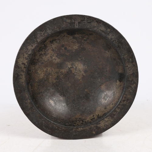 60 - A 16TH CENTURY PEWTER BUMPY-BOTTOM DISH, CIRCA 1500. The narrow flat rim with crowned hammer mark, a... 