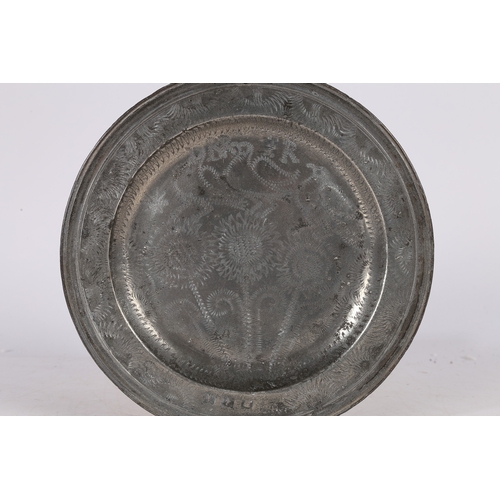 64 - A RARE PEWTER WRIGGLEWORK PLATE, ENGLISH, CIRCA 1700-10. The well designed with three flowering stem... 