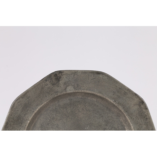 65 - A GEORGE II PEWTER DECAGONAL PLATE, CIRCA 1750. The plain rim engraved with a mantled coat of arms, ... 