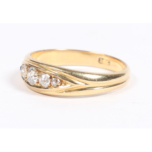 11 - AN 18 CARAT GOLD AND DIAMOND RING. the oval reeded head set with five graduated diamonds, ring size ... 