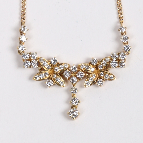 12 - AN 18 CARAT GOLD AND DIAMOND NECKLACE. the central pendant set with three graduated diamonds, flanke... 