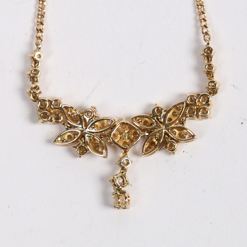 12 - AN 18 CARAT GOLD AND DIAMOND NECKLACE. the central pendant set with three graduated diamonds, flanke... 