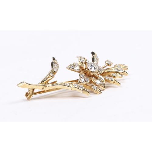 16 - AN 18 CARAT GOLD AND DIAMOND BROOCH. in the form of a flowering branch, the central diamond measurin... 