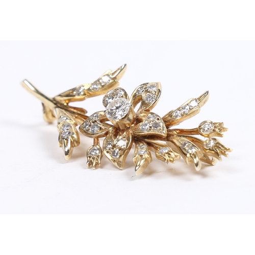 16 - AN 18 CARAT GOLD AND DIAMOND BROOCH. in the form of a flowering branch, the central diamond measurin... 