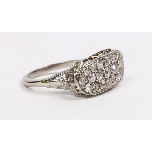 20 - AN 18 CARAT WHITE GOLD AND DIAMOND RING. the oval head set with 21 round cut diamonds and with pierc... 