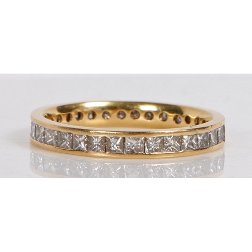 21 - AN 18 CARAT GOLD AND DIAMOND ETERNITY RING. channel set with 32 princess cut diamonds measuring appr... 