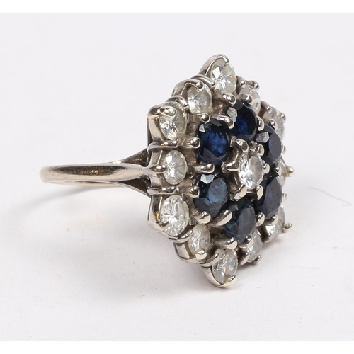 26 - AN 18 CARAT GOLD, SAPPHIRE AND DIAMOND CLUSTER RING. the hexagonal head set with a central sapphire ... 