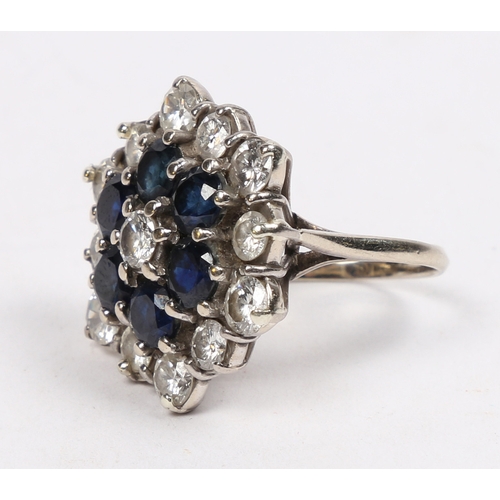 26 - AN 18 CARAT GOLD, SAPPHIRE AND DIAMOND CLUSTER RING. the hexagonal head set with a central sapphire ... 