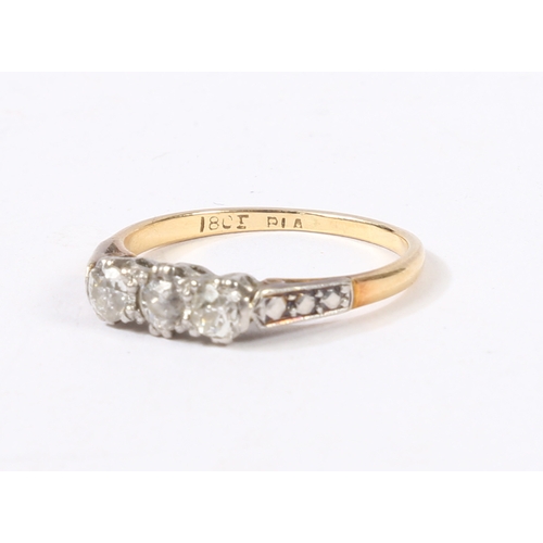 3 - AN 18 CARAT GOLD, PLATINUM AND DIAMOND RING. the head set with three round cut diamonds, flanked by ... 