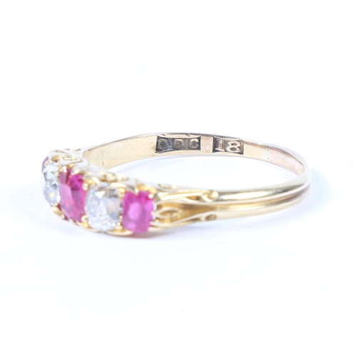 37 - AN 18 CARAT GOLD, RUBY AND DIAMOND RING. the scroll engraved head set with three rubies interspersed... 