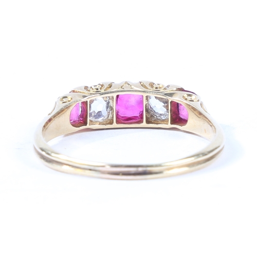 37 - AN 18 CARAT GOLD, RUBY AND DIAMOND RING. the scroll engraved head set with three rubies interspersed... 