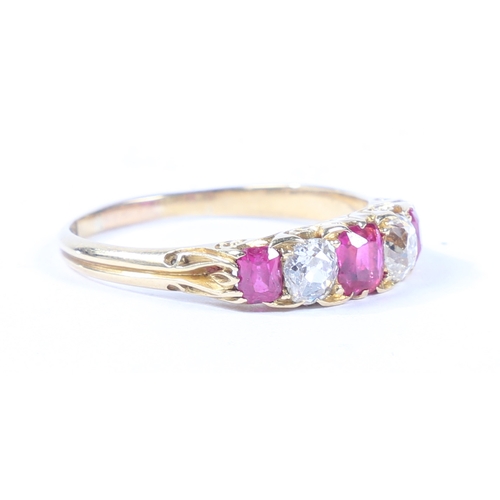 37 - AN 18 CARAT GOLD, RUBY AND DIAMOND RING. the scroll engraved head set with three rubies interspersed... 