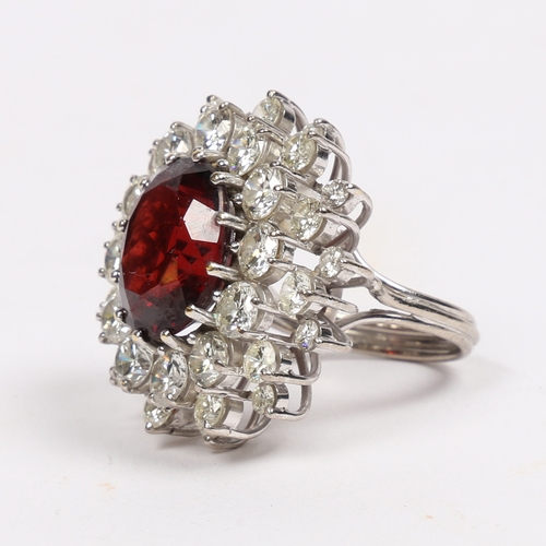 39 - A SUBSTANTIAL DIAMOND AND GARNET CLUSTER RING. the central oval face cut garnet surrounded by round ... 