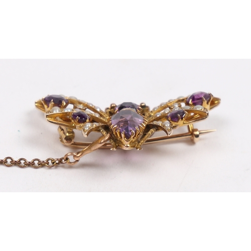 40 - A 9 CARAT GOLD, AMETHYST AND SEED PEARL BUTTERFLY BROOCH. modelled with wings spread, with garnet se... 