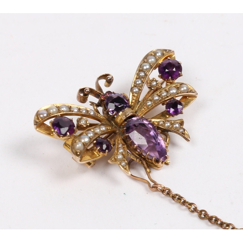 40 - A 9 CARAT GOLD, AMETHYST AND SEED PEARL BUTTERFLY BROOCH. modelled with wings spread, with garnet se... 