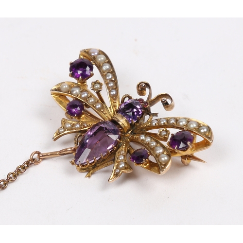 40 - A 9 CARAT GOLD, AMETHYST AND SEED PEARL BUTTERFLY BROOCH. modelled with wings spread, with garnet se... 