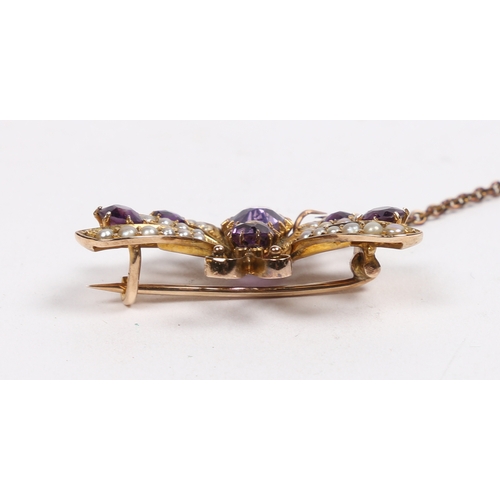 40 - A 9 CARAT GOLD, AMETHYST AND SEED PEARL BUTTERFLY BROOCH. modelled with wings spread, with garnet se... 