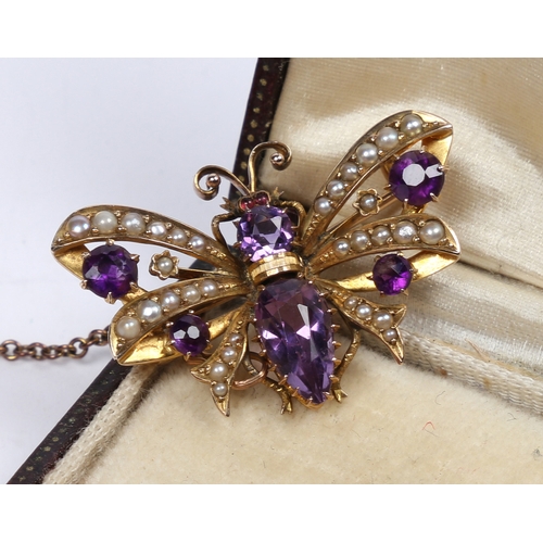 40 - A 9 CARAT GOLD, AMETHYST AND SEED PEARL BUTTERFLY BROOCH. modelled with wings spread, with garnet se... 