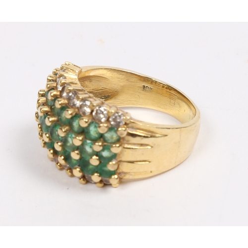 42 - AN 18 CARAT GOLD, EMERALD AND DIAMOND RING. set with three central rows of eight round cut emeralds ... 