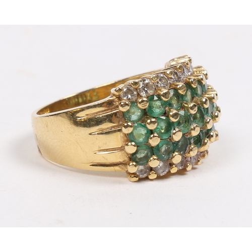 42 - AN 18 CARAT GOLD, EMERALD AND DIAMOND RING. set with three central rows of eight round cut emeralds ... 