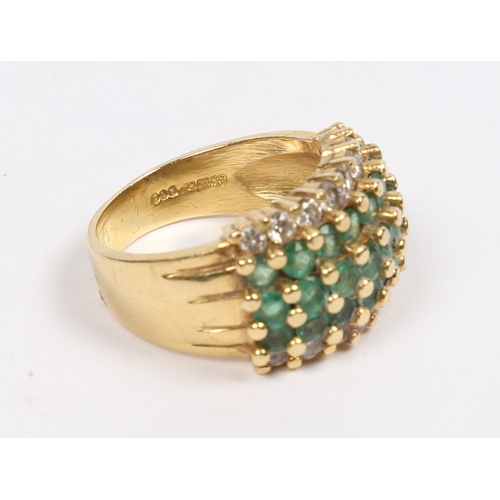 42 - AN 18 CARAT GOLD, EMERALD AND DIAMOND RING. set with three central rows of eight round cut emeralds ... 